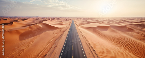 Suggestiva veduta aerea di strada asfaltata che si snoda tra dune di sabbia desertiche