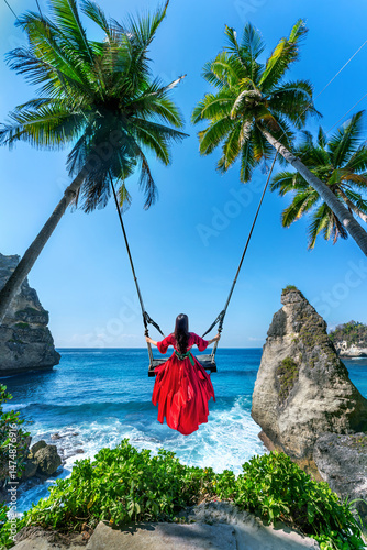 Tourist on Bali swing at Diamond beach in Nusa Penida island, Indonesia.