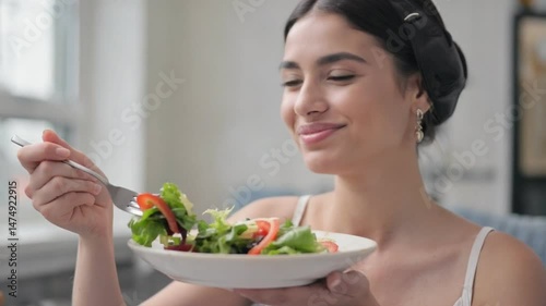 Healthy Bite: A woman savors a fresh, vibrant salad, her expression reflecting a sense of well-being and nourishment. The image conveys a message of wholesome eating habits.