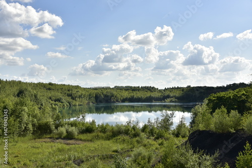 L'une des anciennes carrières remplie d'eau sous des cumulus de beau temps à Écaussinnes-d'Enghien 