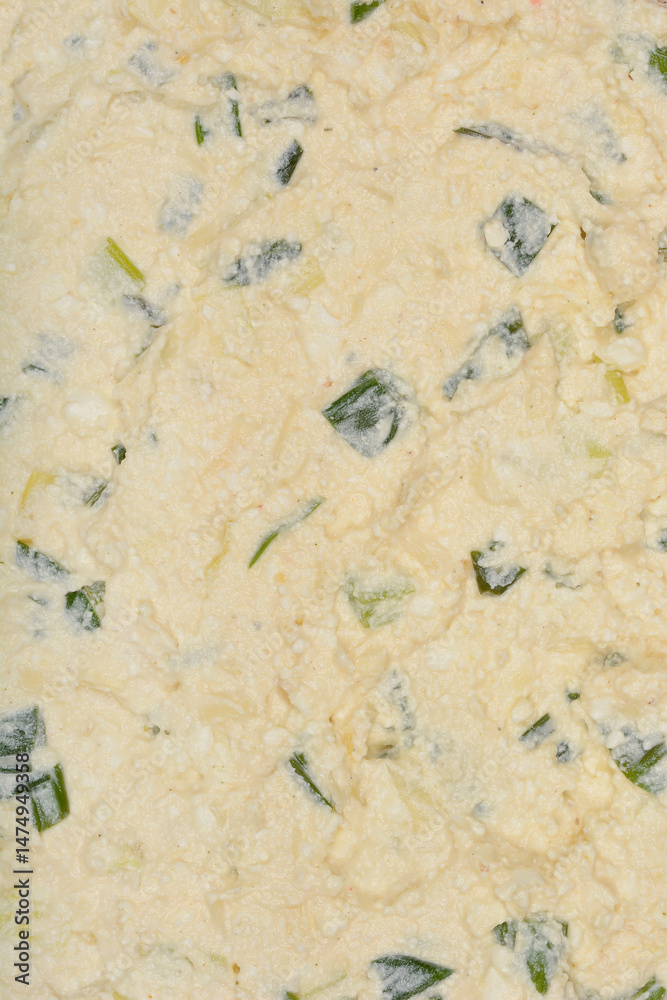 A close-up shows a creamy mixture of fresh cheese, chopped green onions and egg, prepared as a pie filling