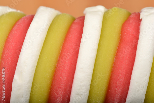 Obraz na płótnie A macro close-up shows the swirled texture of a tri-colored ice cream treat in white, pale green, and pink w salonie