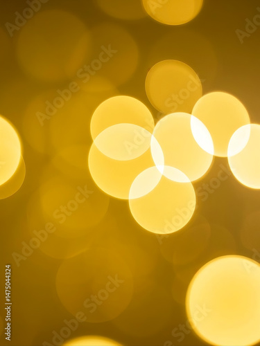 Yellow abstract background with out of focus light circles created using a macro lens and camera blur, forming soft bokeh texture.

