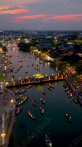 Aerial view of Hoi An old town or Hoian ancient town in evening. Royalty high-quality free stock footage top of Hoai river and boat tour night traffic. One of the most popular touristic destination