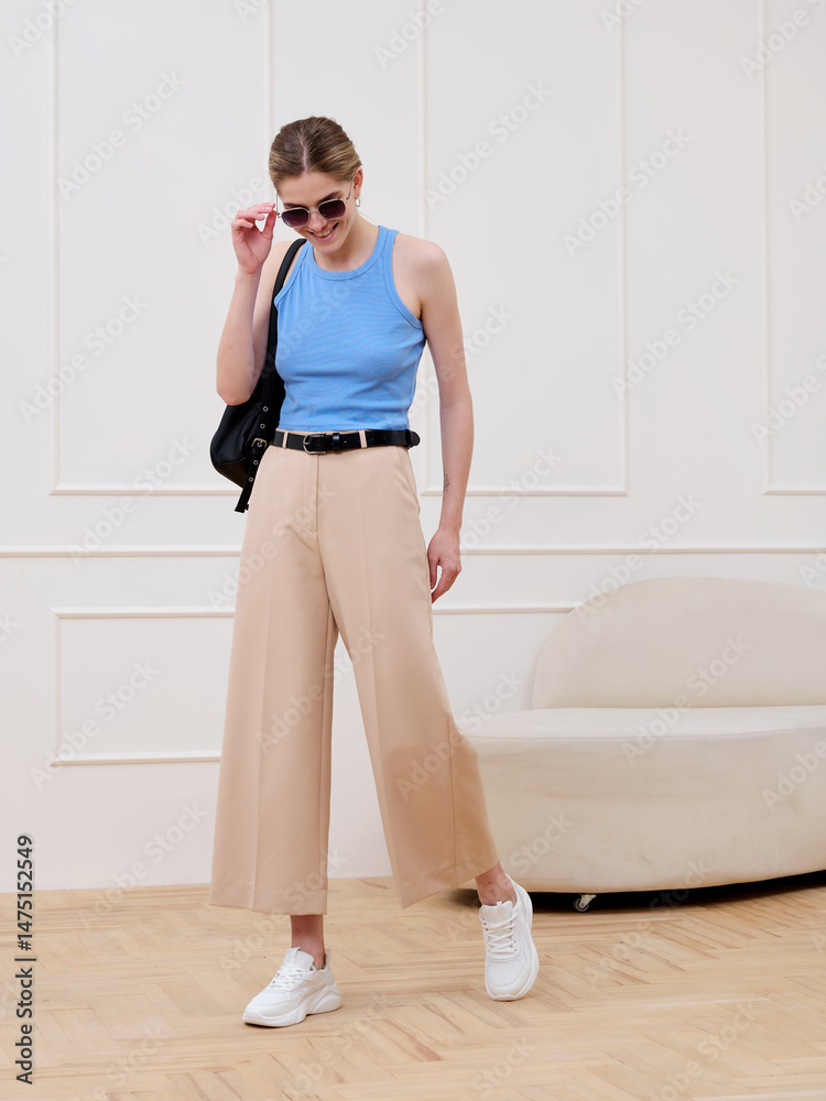 Fototapeta premium A girl in stylish clothes poses in a studio.