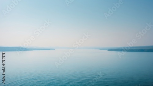 Fototapeta Naklejka Na Ścianę i Meble -  Scenic landscape showcasing a big lake with reflections, hills, and alpine peaks in the background