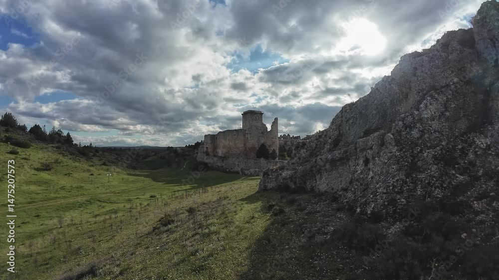 Ruins of rocca calascio castle emerging from the green valley under cloudy sky Ruins of rocca calascio castle emerging from the green valley under cloudy sky