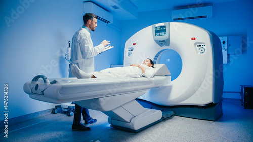 Bild auf Leinwand Handsome male physician gesturing while smiling at patient resting on scan bed