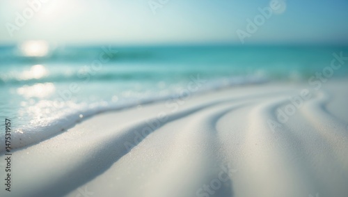 Fototapeta Naklejka Na Ścianę i Meble -  Beautiful vista of a pristine white sand beach with azure water. Summertime beach setting for holidays. Waves rolling onto the sandy shore.