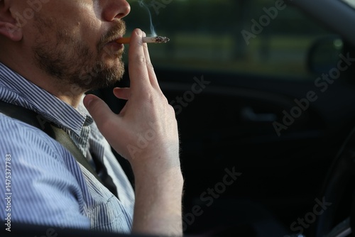 Man smoking cigarette in car, closeup. Space for text