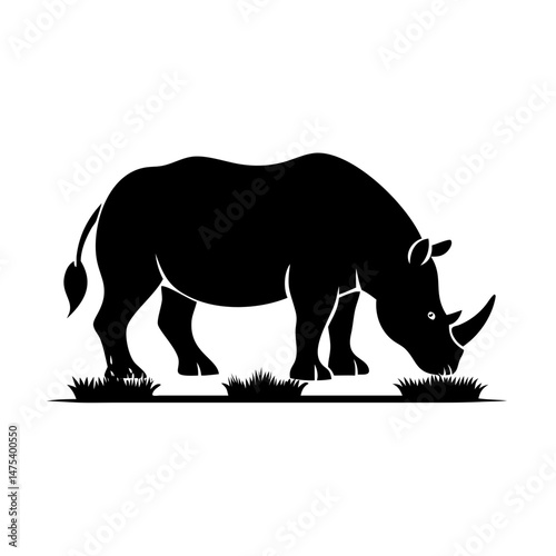 Black and white silhouette of a rhinoceros grazing on grass in daytime