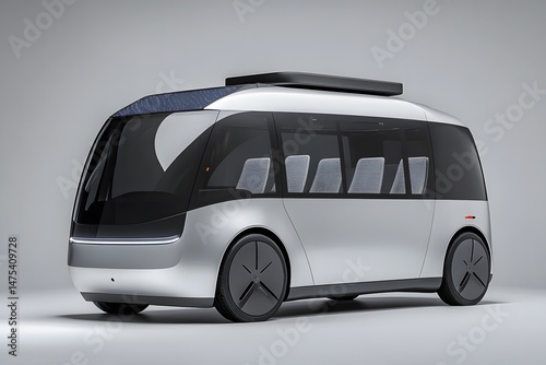 A silver bus with large windows and a black roof rack on a plain gray background in a studio shot