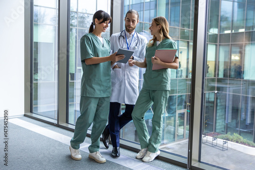 Team of young doctors discussing something and looking interested and involved