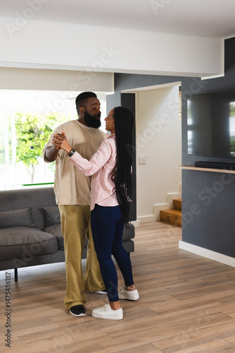 African American couple dancing together at home, enjoying joyful moment