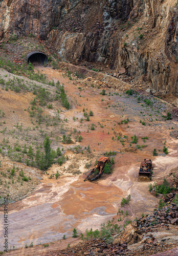 Tablou pe pânză In the former copper mine of Falun Sweden, rusted vehicles lie amid a colorful red soil landscape of minerals