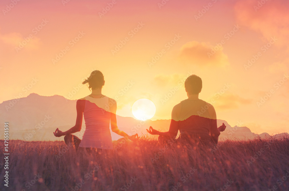 Fototapeta premium Couple practicing meditation at sunset 