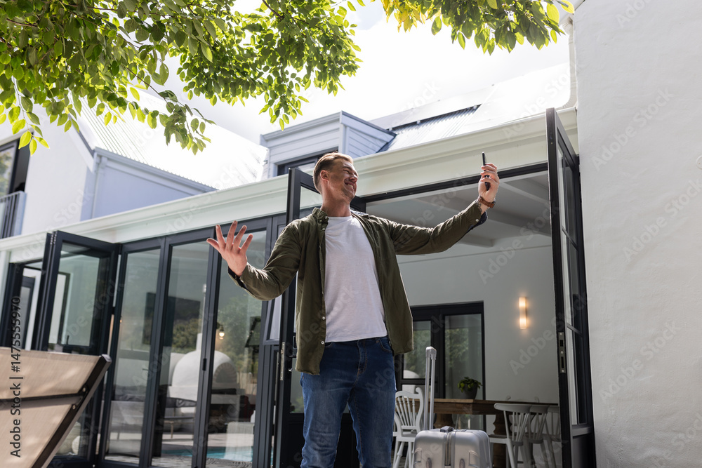 Fototapeta premium Man outdoors taking selfie with smartphone, smiling and enjoying sunny day