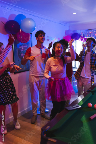 Teenagers celebrating at home, dancing and enjoying lively party atmosphere