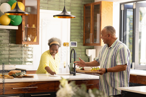 African American senior couple enjoying breakfast together in modern kitchen