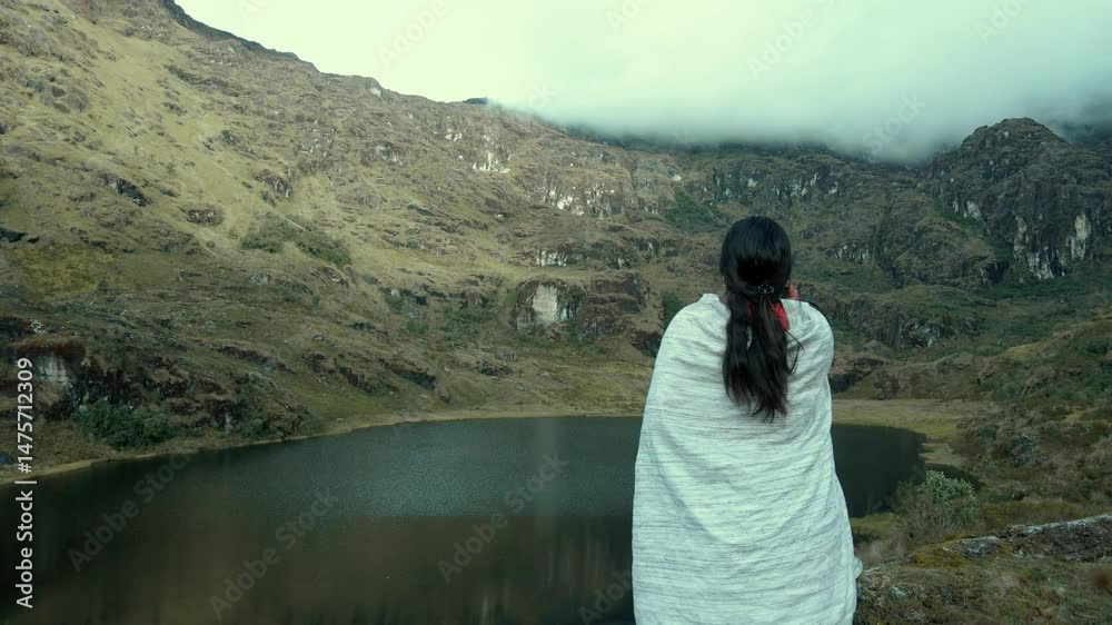 Video de una feliz y bonita campesina en una laguna hablando por un teléfono celular en los Andes peruanos. Mujer usando teléfono móvil.Quechua.Estilo de vida.