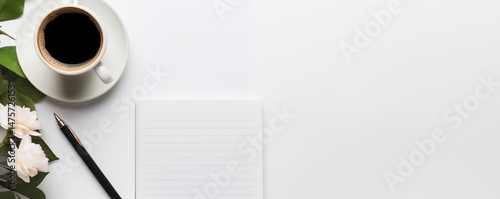 Coffee cup with blank striped notebook and pen on white background. Workspace with drink and stationery. Copy space for text creative work or planning.