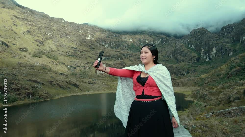 Video de una feliz y bonita campesina en una laguna hablando por un teléfono celular en los Andes peruanos. Mujer usando teléfono móvil.Quechua.Estilo de vida.