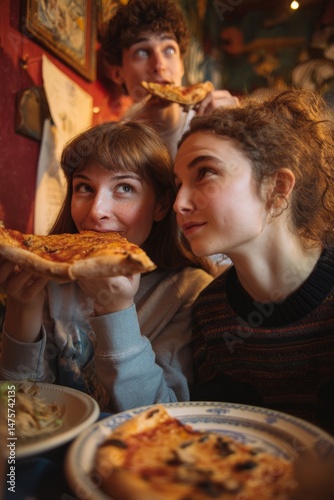 Three friends share pizza, laughing and enjoying each other's company at a restaurant.
