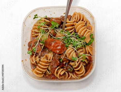 Cooked organic pasta healthy meal with tomatoes in plastic bowl