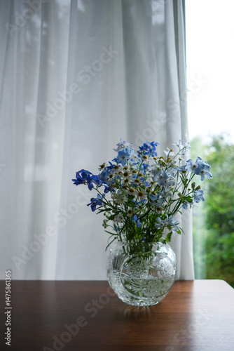 テーブルの上の花瓶に入った青と白の花束