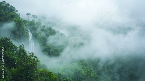 A misty morning scene with the Detian Waterfall cascading dramatically, the surrounding landscape enveloped in soft clouds and lush greenery.