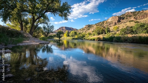 A peaceful river scene with a rainbow arching across the sky, its vibrant colors reflecting off the smooth surface of the water crossing through the national park.