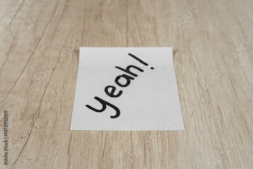 “yes” written with black marker pen on a sticky note positioned in the center
