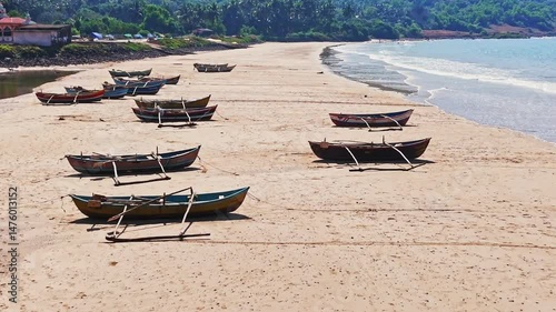 Aerial view over traditional Dhoni fishing vessels, moored on a beach in India photo