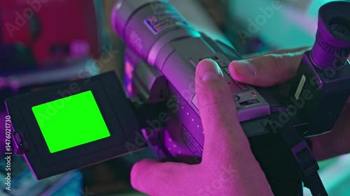 Hand Holding Old Video Camera with Green Screen LCD