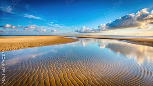 Tranquil beach scene at low tide with a narrow sandbar exposed in the foreground , serene
