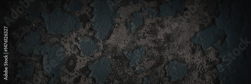 Dark wide panoramic background. Peeling paint on a concrete wall. Dark grunge texture of old cracked flaking paint. Weathered rough painted surface. Patterns of cracks. Darkness background for design.