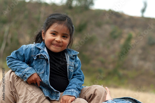 Portrait of smiling indigenous girl sitting outdoors in nature