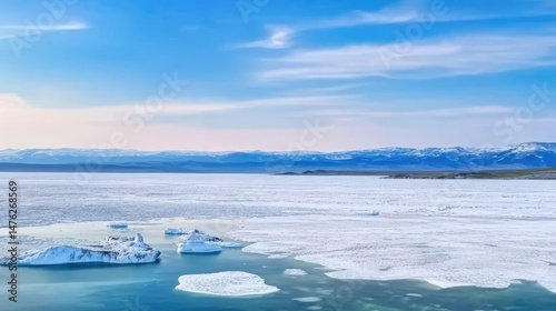 Lake Baikal in May, viewed from Olkhon Island, with small ice floes on the lake. Spring landscape with distant mountains and natural ice formations, capturing the changing season and spring travel vib