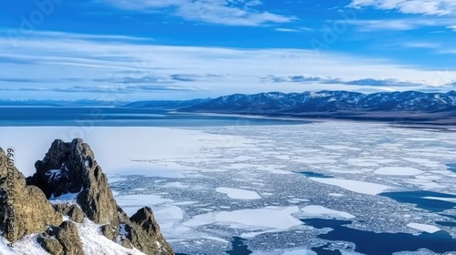 Lake Baikal in May, viewed from Olkhon Island, with small ice floes on the lake. Spring landscape with distant mountains and natural ice formations, capturing the changing season and spring travel vib