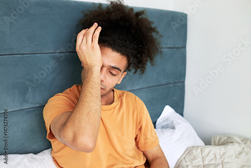 Foto Indoor image of tired black sleep-deprived guy of 20s with afro hairstyle trying