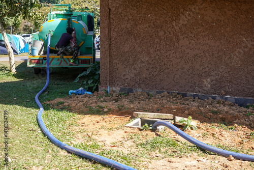Konstfotografi Technician from the local sewage management company use pipe hose of sewage truck car sucked out waste from the septic tank at Lam Ta Khong campground, Khao Yai National Park, Thailand