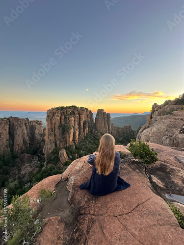 Scenic sunset at the Valley of Desolation in Graaff-Reinet, South Africa with silhouette of a woman admiring the view, 