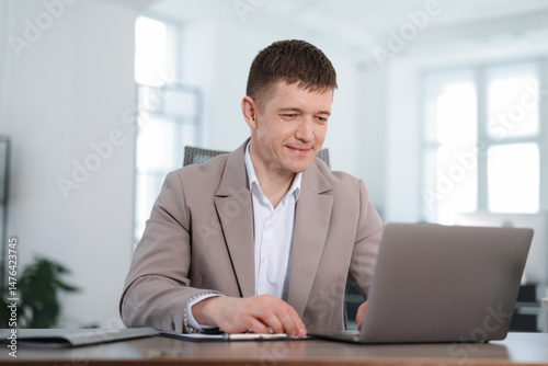 Man working on laptop at desk in office