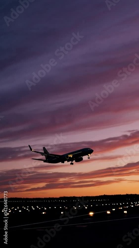 Airplane landing against vibrant sunset: captivating dusk in flight approach
