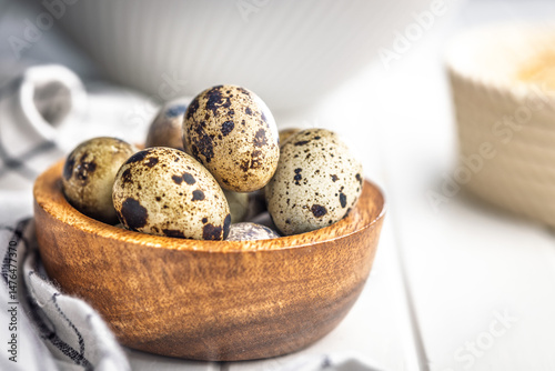 Obraz na płótnie Spotted quail eggs in bowl on kitchen table. w salonie