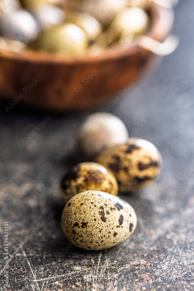 Spotted quail eggs on black table.