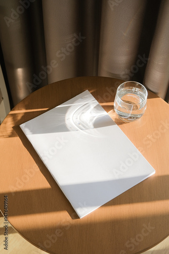 magazine cover mockup design. blank magazine mockup on wooden coffee table with glass of water