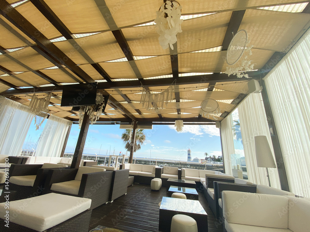 Fototapeta premium Coastal Lounge Terrace with Modern Seating and Lighthouse Vie