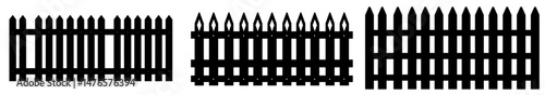 A rural fence made of planks, with a black silhouette of a wooden barrier