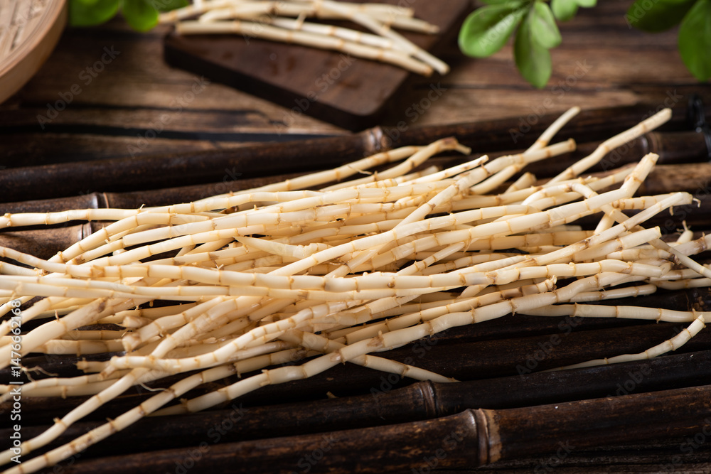 Couch grass herb root used in herbal medicine on wooden table.